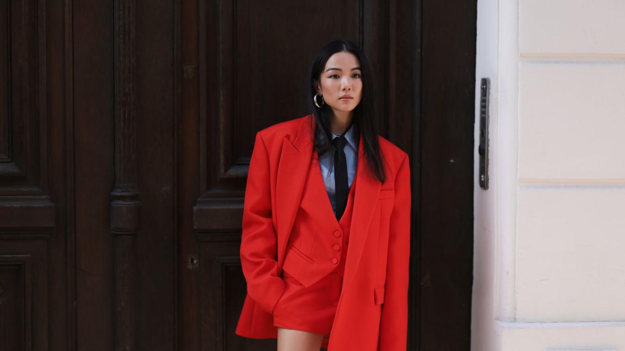 paris, france october 01 yoyo cao is seen wearing a blue shirt with a black tie, a black valentino bag, silver earrings, a red skirt, an oversized red blazer as well as a red vest before the valentino fashion show during the womenswear springsummer 2024 as part of paris fashion week on october 01, 2023 in paris, france photo by jeremy moellergetty images