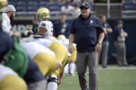 FILE - In this Saturday, Dec. 28, 2019, file photo, Notre Dame head coach Brian Kelly, right, watches warmups before the Camping World Bowl NCAA college football game against Iowa State in Orlando, Fla. Normally, in March, college football teams all over the country would be preparing for the upcoming season. That's gone now, because of the new coronavirus pandemic, and coaches are trying to figure out how to recreate some of what has been lost. (AP Photo/Phelan M. Ebenhack, File)