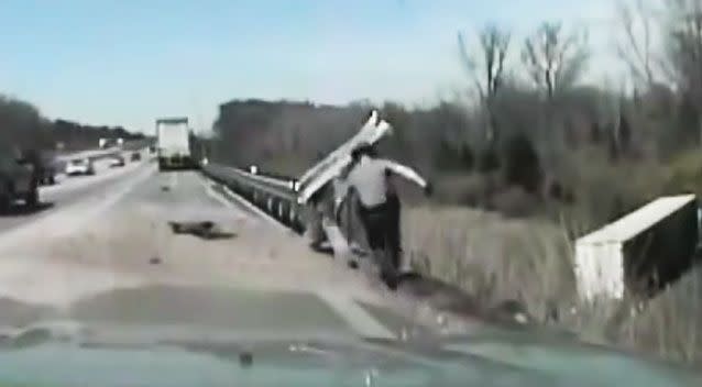 Trooper Eric Devers wasted no time getting to the injured truck driver. Photo: Ohio State Highway Patrol