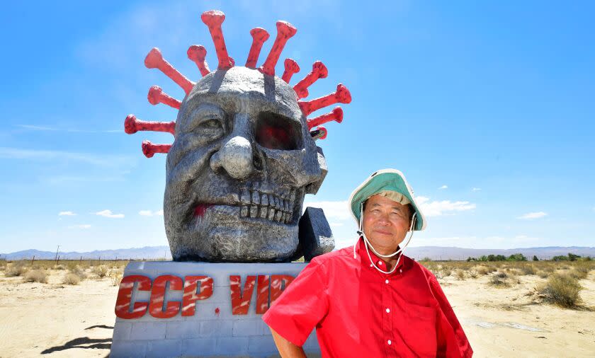 Artist and sculptor Chen Weiming poses beside his latest sculpture "ccp virus" on display at Liberty Sculpture Park in the Mojave desert town of Yermo, California on June 1, 2021. - The park and sculptures, located off the Interstate 15 freeway between Los Angeles and Las Vegas, are the creation of Chinese-born New Zealand artist and sculptor Chen Weiming, who unveiled "Tank Man" two years ago on the 30th anniversary of the 1989 pro-democracy movement in Beijing's Tiananmen Square, and where new pieces such as Chen's latest coronavirus sculpture "ccp virus" are displayed. In 2008 Chen created the 6.4 metre replica Goddess of Democracy statue for the Chinese University of Hong Kong and in 1991 was comissioned by the New Zealand government to create a 3-metre-bronze statue of Edmund Hillary. - RESTRICTED TO EDITORIAL USE - MANDATORY MENTION OF THE ARTIST UPON PUBLICATION - TO ILLUSTRATE THE EVENT AS SPECIFIED IN THE CAPTION (Photo by Frederic J. BROWN / AFP) / RESTRICTED TO EDITORIAL USE - MANDATORY MENTION OF THE ARTIST UPON PUBLICATION - TO ILLUSTRATE THE EVENT AS SPECIFIED IN THE CAPTION / RESTRICTED TO EDITORIAL USE - MANDATORY MENTION OF THE ARTIST UPON PUBLICATION - TO ILLUSTRATE THE EVENT AS SPECIFIED IN THE CAPTION (Photo by FREDERIC J. BROWN/AFP via Getty Images)