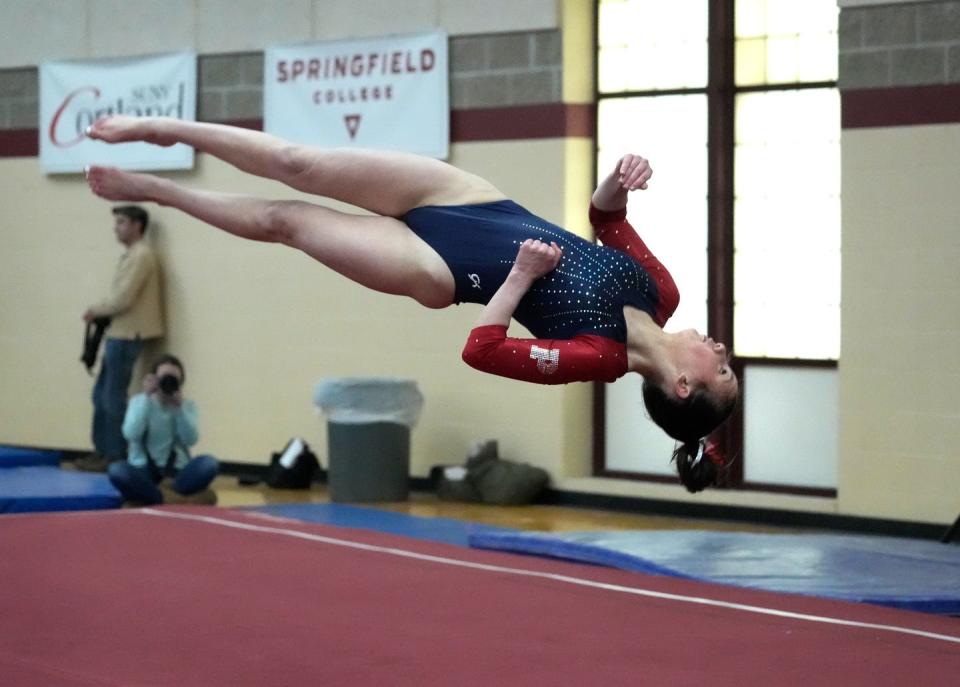 Portsmouth team captain Rowan Snyder performs a midair twist during her floor routine.