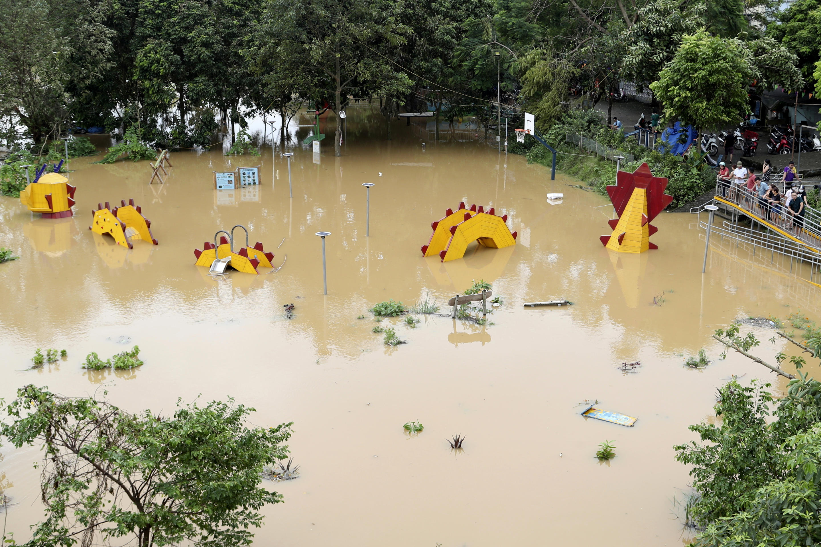 People look on a submerged dragon structure in a playground, following Typhoon Yagi in Hanoi, Vietnam on Tuesday, Sept. 10, 2024. (Huy Han/AP)