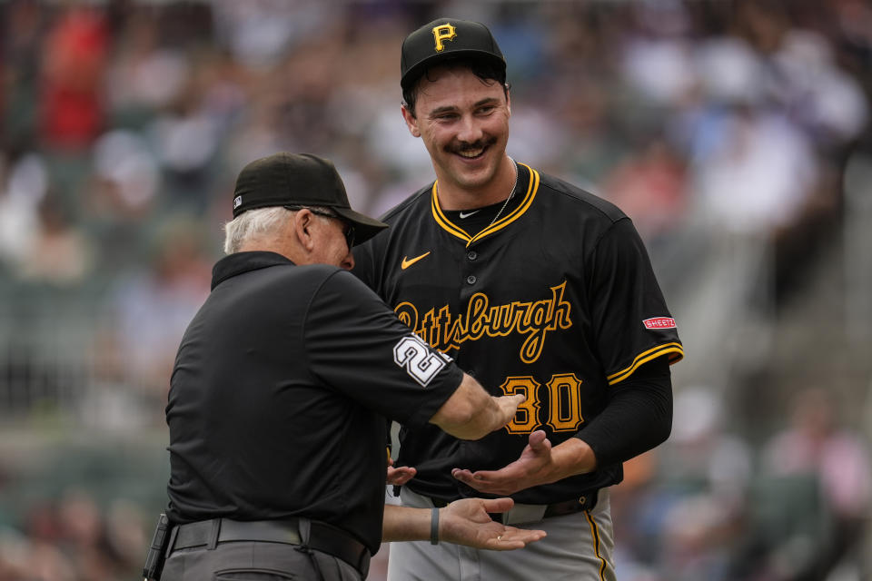 An official checks the glove and hands of Pittsburgh Pirates pitcher Paul Skenes (30) in the third inning of a baseball game against the Atlanta Braves, Saturday, June 29, 2024, in Atlanta. (AP Photo/Mike Stewart)