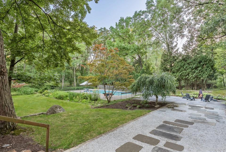 A stone path leads to a 30,000-gallon, in-ground pool in the backyard of a mid-century modern house in Farmington Hills known as the Arthur Beckwith house, designed by award-winning architect William Kessler in 1960.