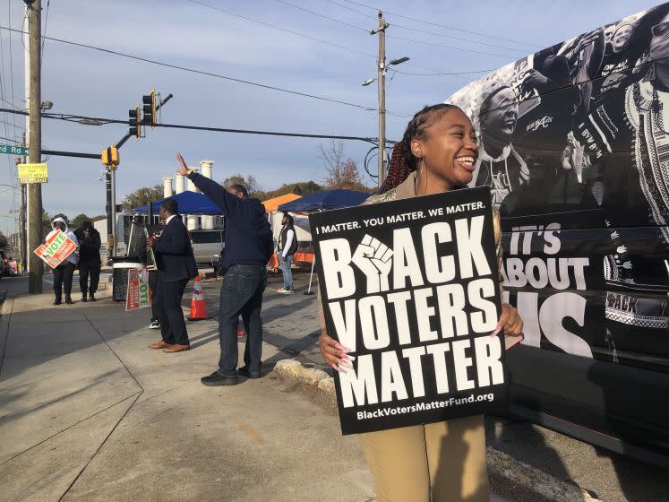 A community activist works to get out the vote near a polling station in Southwest Atlanta ahead of Georgia's Dec. 6 US Senate runoff election between Sen. Raphael Warnock and Herschel Walker.