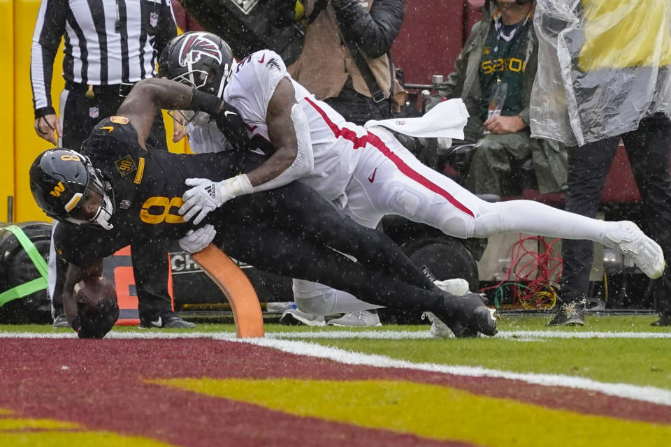 Washington Commanders running back Brian Robinson Jr. (8) scores a touchdown against Atlanta Falcons linebacker Mykal Walker (3) during the first half of an NFL football game, Sunday, Nov. 27, 2022, in Landover, Md. (AP Photo/Alex Brandon)