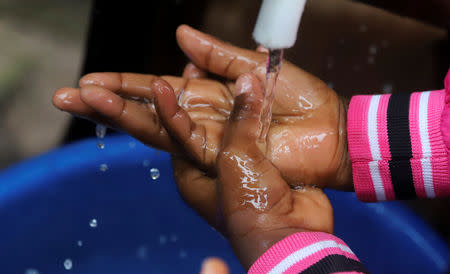 A Congolese child washes her hands as a preventive measure against Ebola at the Church of Christ in Mbandaka, Democratic Republic of Congo May 20, 2018. REUTERS/Kenny Katombe/File Photo