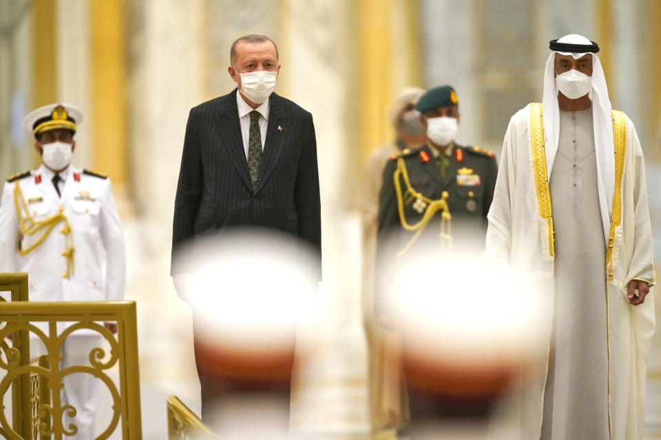 Turkish President Recep Tayyip Erdogan, center left, and Abu Dhabi Crown Prince Sheikh Mohammed bin Zayed Al Nahyan, right, stand for an honor guard at Qasr Al-Watan in Abu Dhabi, United Arab Emirates, Monday, Feb. 14, 2022. Erdogan traveled Monday to the United Arab Emirates, a trip signaling a further thaw in relations strained over the two nations' approaches to Islamists in the wake of the 2011 Arab Spring. (AP Photo/Jon Gambrell)
