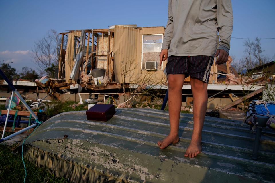 Aiden Locobon stands on a boat near the remnants of his family's home destroyed by Hurricane Ida, Saturday, Sept. 4, 2021, in Dulac, La.