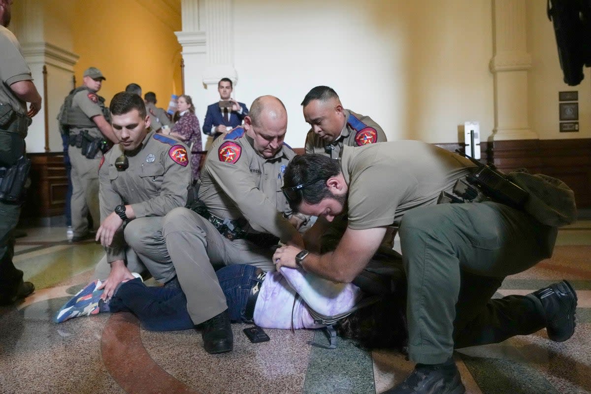 An LGBT+ rights activist is detained by Department of Public Safety troopers as activists protest SB14 outside the House of Representatives gallery at the Texas State Capitol in Austin (AP)