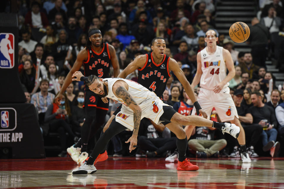 Toronto Raptors forward Scottie Barnes (4) and Miami Heat forward Caleb Martin (16) look for a loose ball during the first half of an NBA basketball game in Toronto on Tuesday, March 28, 2023. (Christopher Katsarov/The Canadian Press via AP)