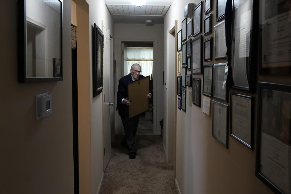 CORRECTS DATE TO APRIL 7 - World War II veteran Art Fishman shows some of his memorabilia, Monday, April 4, 2022, in Oak Park, Mich. Fishman's dream of a Michigan state World War II memorial is about to take one more step toward reality. Fishman, who sailed on a Navy destroyer in the Pacific theater as an 18-year-old, was to be among those on hand Thursday, April 7 when ground is broken for The Michigan WWII Legacy Memorial in Royal Oak, Mich. (AP Photo/Carlos Osorio)