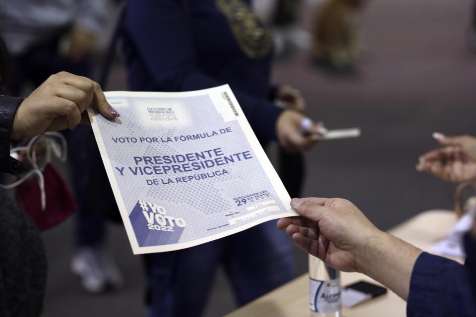 Se entrega una boleta a un votante durante las elecciones presidenciales en el centro de votación principal, Corferias, en Bogotá, Colombia, el domingo 29 de mayo de 2022. (Foto AP/Leonardo Muñoz)