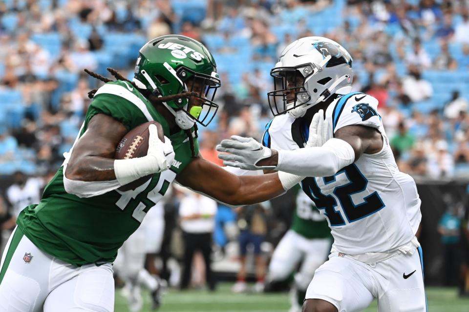Aug 12, 2023; Charlotte, North Carolina, USA; New York Jets tight end E.J. Jenkins (49) scores a touchdown as Carolina Panthers safety Sam Franklin Jr. (42) defends in the fourth quarter at Bank of America Stadium. Mandatory Credit: Bob Donnan-USA TODAY Sports