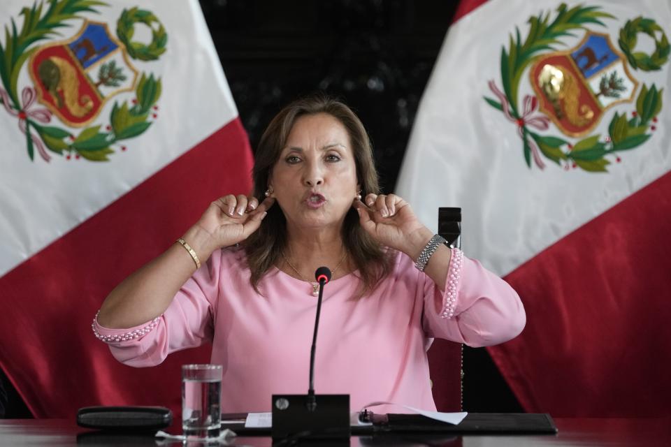 Peru's President Dina Boluarte points to the earrings she is wearing, during a press conference at Government Palace, in Lima, Peru, Friday, April 5, 2024. Authorities are investigating on whether she illegally received hundreds of thousands of dollars in cash, luxury watches and jewelry. (AP Photo/Martin Mejia)