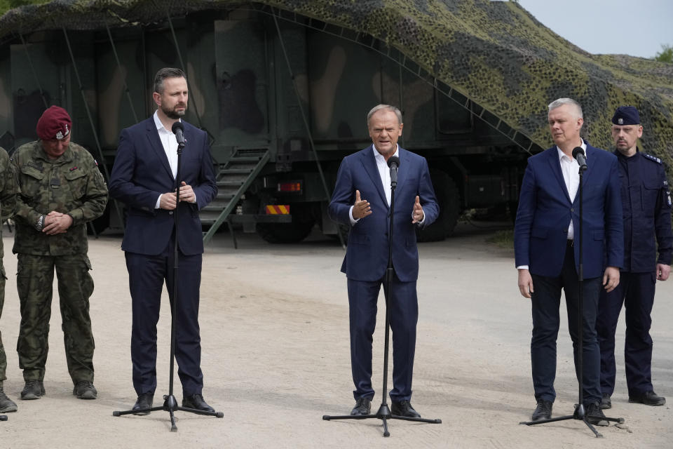 FILE - Poland's Prime Minister Donald Tusk, centre, Defense Minister Wladyslaw Kosiniak-Kamysz, centre left, and Interior Minister Tomasz Siemoniak,, visit visit troops who patrol Poland's border with Belarus, in Dubicze Cerkiewna, eastern Poland on Wednesday, May 29, 2024. Poland says neighboring Belarus and its main supporter Russia are behind a surging push by migrants in Belarus toward the European Union. (AP Photo/Czarek Sokolowski, File)