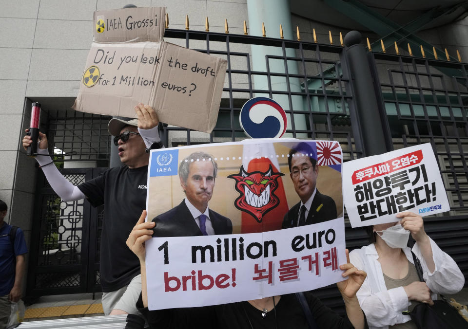 A protester with a banner showing an image of Rafael Mariano Grossi, Director General of the International Atomic Energy Agency, left, and Japanese Prime Minister Fumio Kishida protests against the Japanese government's decision to release treated radioactive water from the damaged Fukushima nuclear power plant, in Seoul, South Korea, Saturday, July 8, 2023. (AP Photo/Ahn Young-joon)