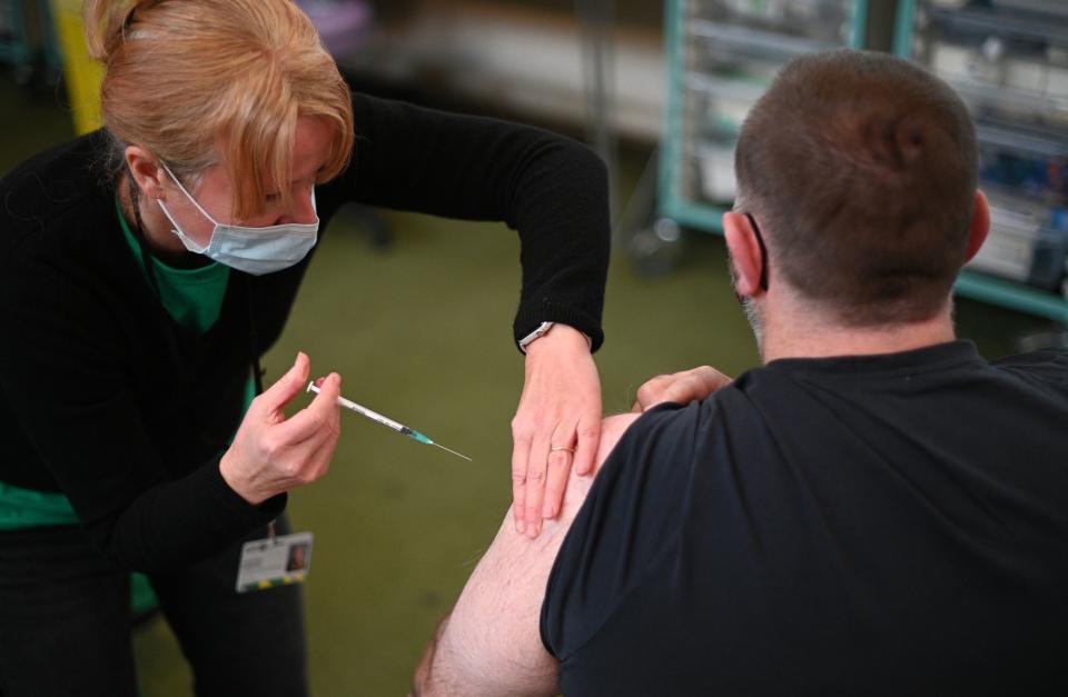 A member of the public receives a second dose of a Pfizer Covid-19 vaccine jab at a temporary coronavirus vaccination centre set up inside St John's Church in west London on December 4, 2021. - Britain, which has been among the hardest hit by Covid-19 with more than 145,000 deaths, is racing to offer third doses of coronavirus vaccines to all adults aged over 18 through its state-run National Health Service. (Photo by Daniel LEAL / AFP) (Photo by DANIEL LEAL/AFP via Getty Images)