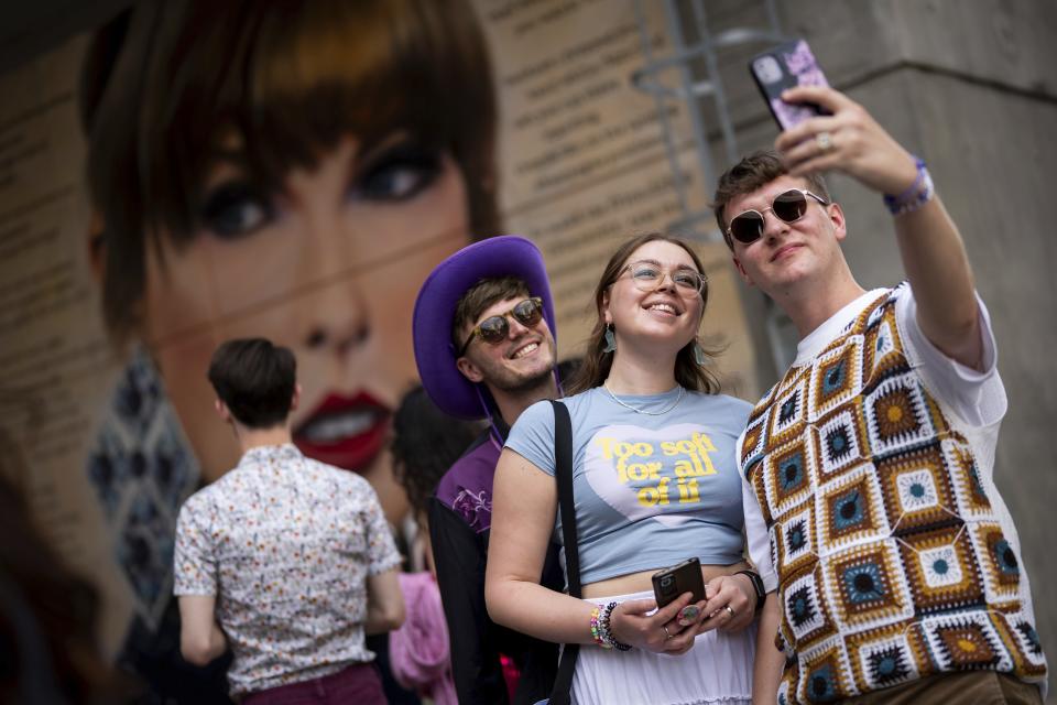 Taylor Swift fans pose for a photograph besides a mural, commissioned by London Mayor Sadiq Khan, before the first London concert of the Eras Tour on Friday, June 21, 2024 in London. (Photo by Scott A Garfitt/Invision/AP)