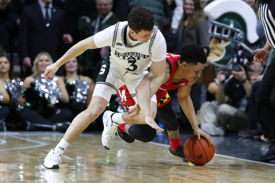 Michigan State guard Foster Loyer (3) fouls Maryland guard Anthony Cowan Jr. (1) during a loose ball in the first half of an NCAA college basketball game in East Lansing, Mich., Saturday, Feb. 15, 2020. (AP Photo/Paul Sancya)