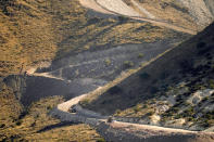 FILE - A pathway cleared by explosives to make way for border wall construction separates Mexico, right, and the United States, Wednesday, Dec. 9, 2020, in Guadalupe Canyon, Ariz. President Biden on Wednesday ordered a "pause" on all wall construction within a week, one of 17 executive edicts issued on his first day in office, including six dealing with immigration. The order leaves projects across the border unfinished and under contract after Trump worked feverishly last year to reach 450 miles, a goal he announced was achieved eight days before leaving office. (AP Photo/Matt York)