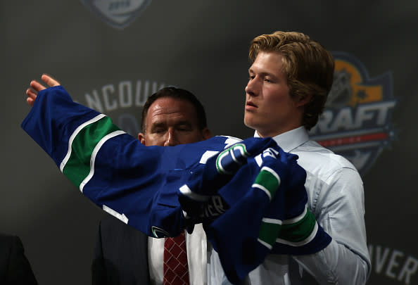 SUNRISE, FL - JUNE 26: Brock Boeser puts on his jersey after being selected 23rd overall by the Vancouver Canucks during Round One of the 2015 NHL Draft at BB&T Center on June 26, 2015 in Sunrise, Florida. (Photo by Dave Sandford/NHLI via Getty Images)