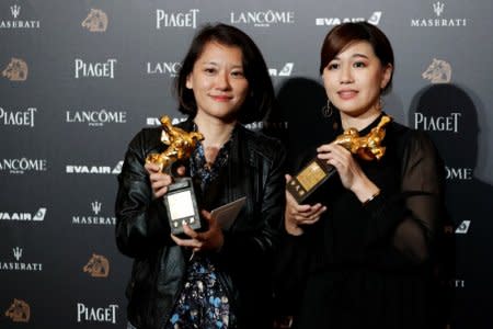 Taiwan's director Yue Fu (R) poses backstage after winning Best Documentary for her movie