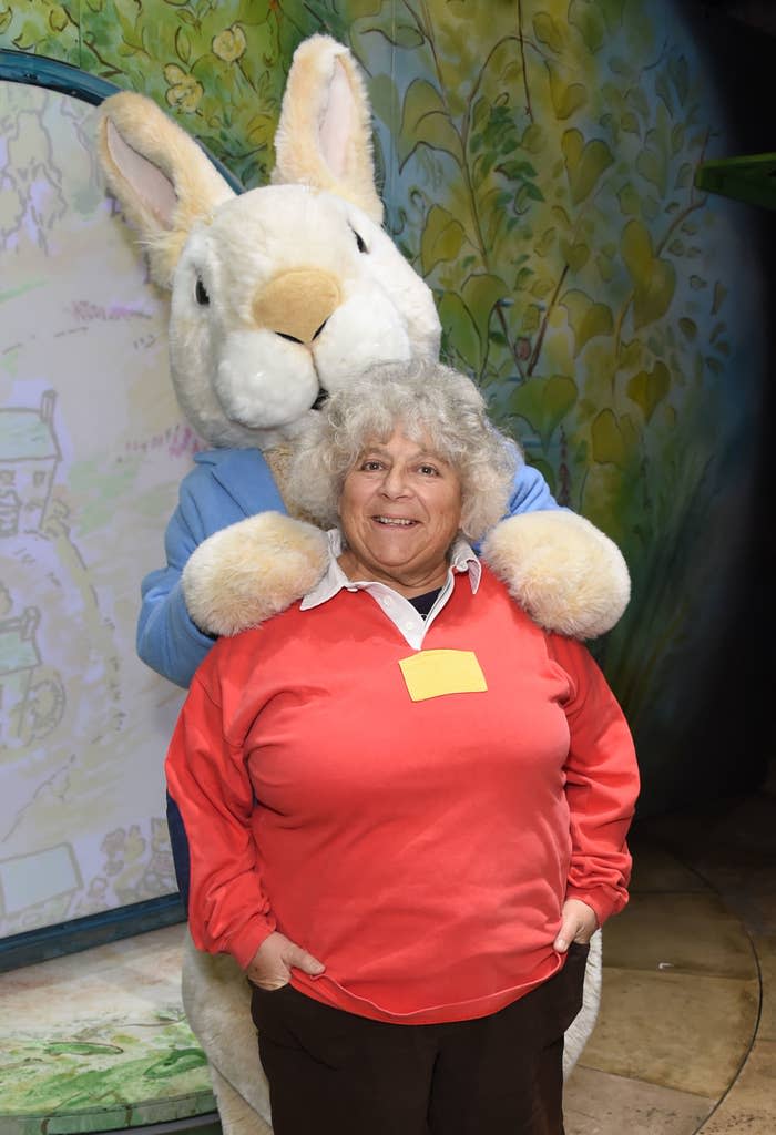 she's posing in front of a person dressed as a rabbit