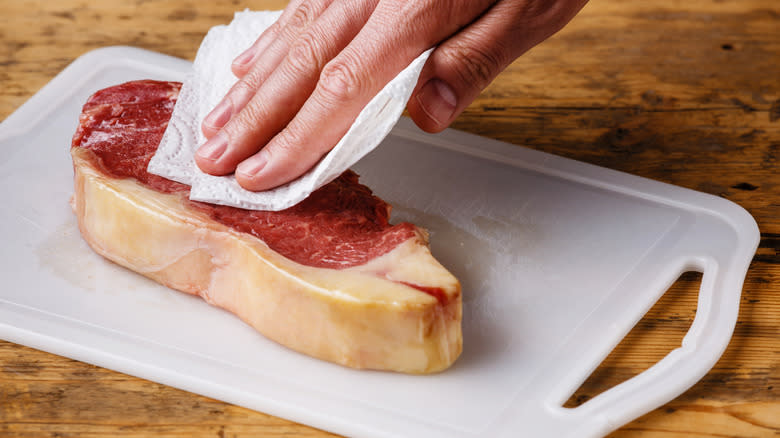 blotting steak with paper towel
