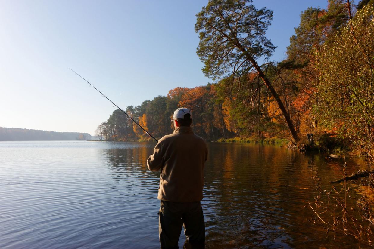 fisherman catching the fish at sunny autumnal day