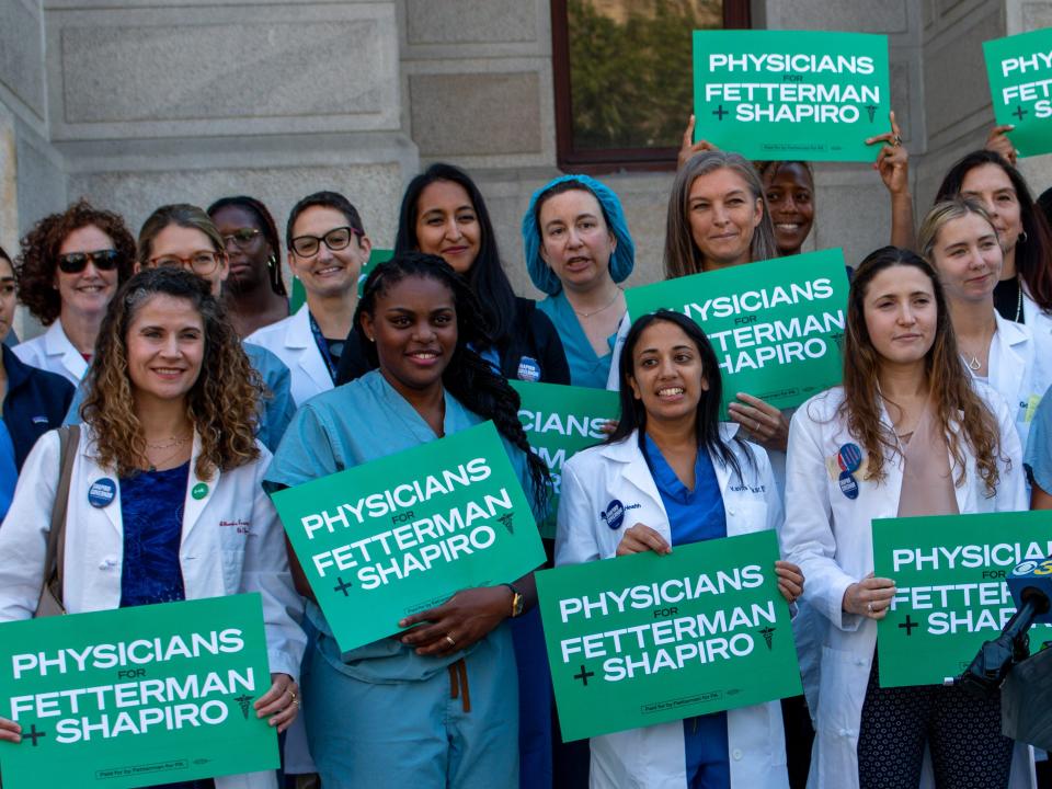 doctors holding signs that say "Physicians for Fetterman + Shapiro"