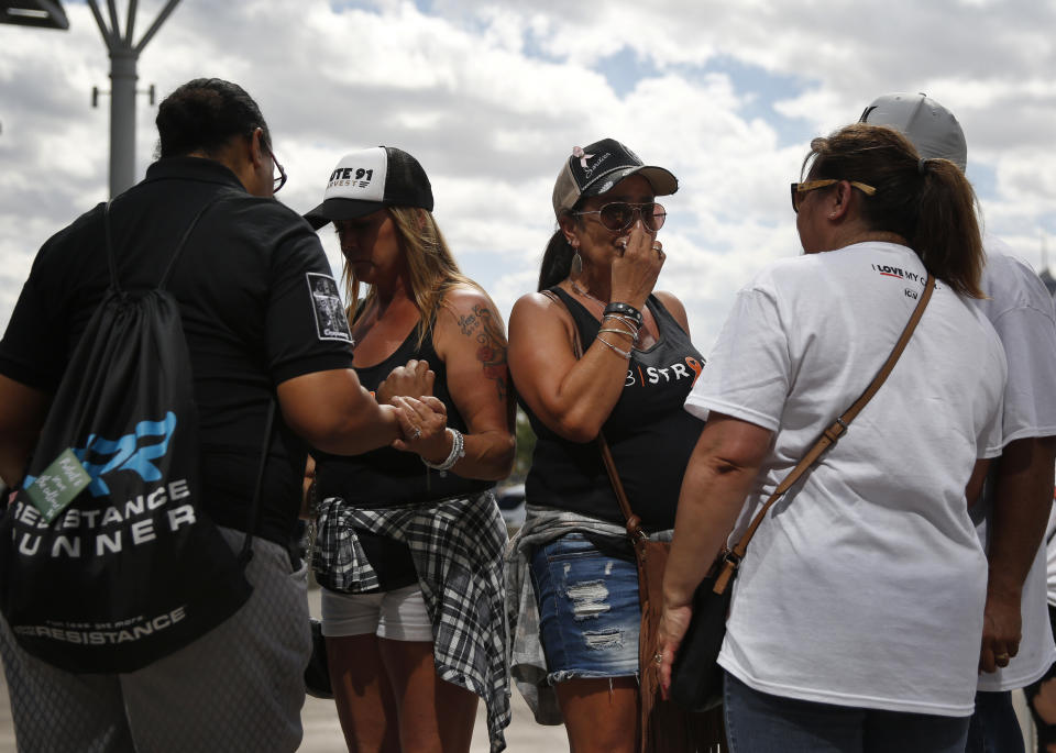 Norma Felix, center right, and Cheryl Seguin, center left, pray with others at a prayer service on the anniversary of the Oct.1, 2017 mass shooting, Monday, Oct. 1, 2018, in Las Vegas. The two attended the country music festival last year and came back to Las Vegas for the anniversary. (AP Photo/John Locher)