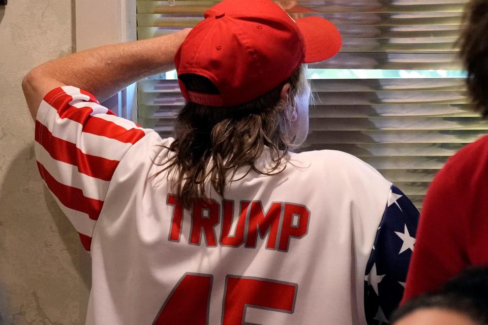 A supporter keeps watch for the arrival of former President Donald Trump at the Grimes Community Complex Park, Tuesday, July 18, 2023, in Des Moines, Iowa.