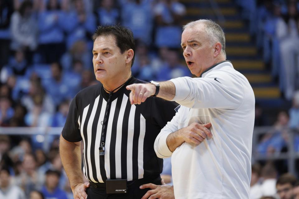 Virginia Tech head coach Mike Young, right, speaks with official Raymie Styons, left, during the first half of an NCAA college basketball game against North Carolina in Chapel Hill, N.C., Saturday, Feb. 17, 2024. (AP Photo/Ben McKeown)