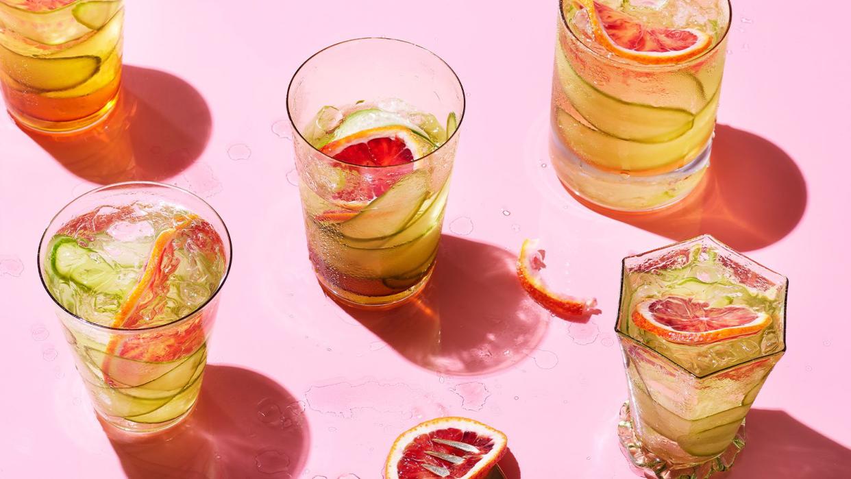 Cocktails with grapefruit and cucumber against pink background