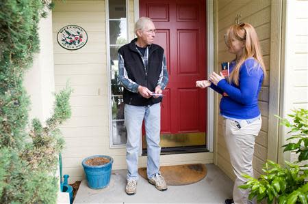 Stacey Barrack (R), hired by the Defending Main Street super PAC to get out the vote for Congressman Mike Simpson (R-ID), speaks with resident Richard Fox about the upcoming Republican primary election in Boise, Idaho May 10, 2014. REUTERS/Patrick Sweeney