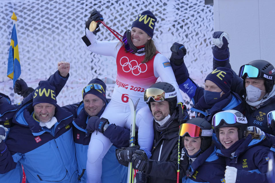 Sweden's Sara Hector celebrates on the shoulders of teammates after taking the gold medal for the women's giant slalom at the 2022 Winter Olympics, Monday, Feb. 7, 2022, in the Yanqing district of Beijing. (AP Photo/Luca Bruno)