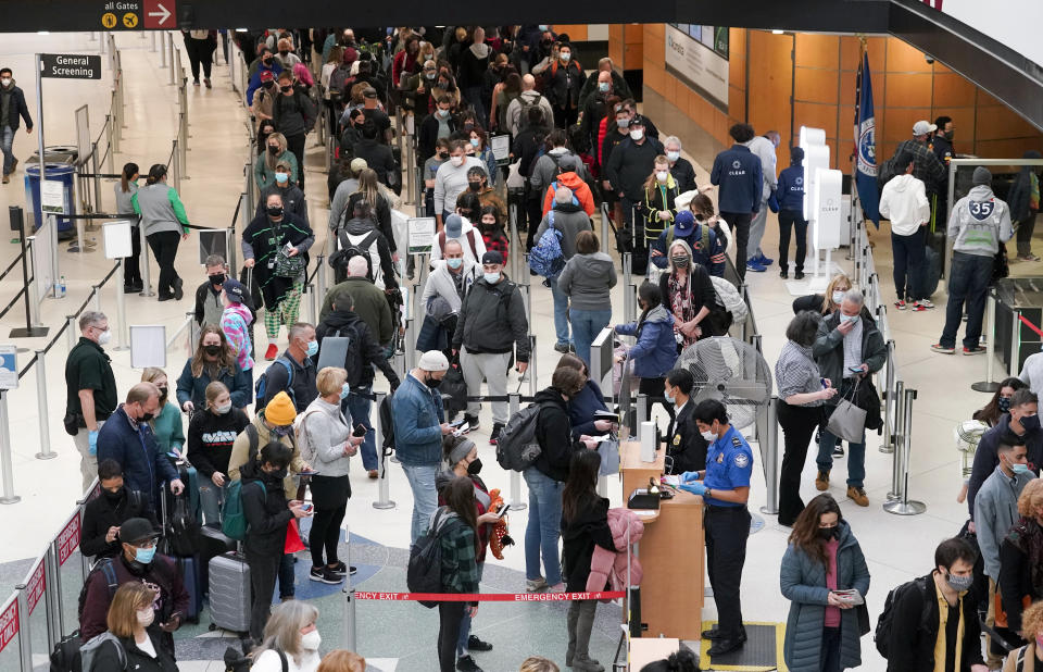 FILE - Travelers wear masks as they wait in a line for a TSA security check, Dec. 10, 2021, at Seattle-Tacoma International Airport in Seattle. President Joe Biden on Monday, Dec. 13, 2021, will sign an executive order aimed at saving Americans time and frustration when seeking a broad array of federal services, like renewing passports, applying for Social Security benefits and getting aid after natural disasters. (AP Photo/Ted S. Warren, File)