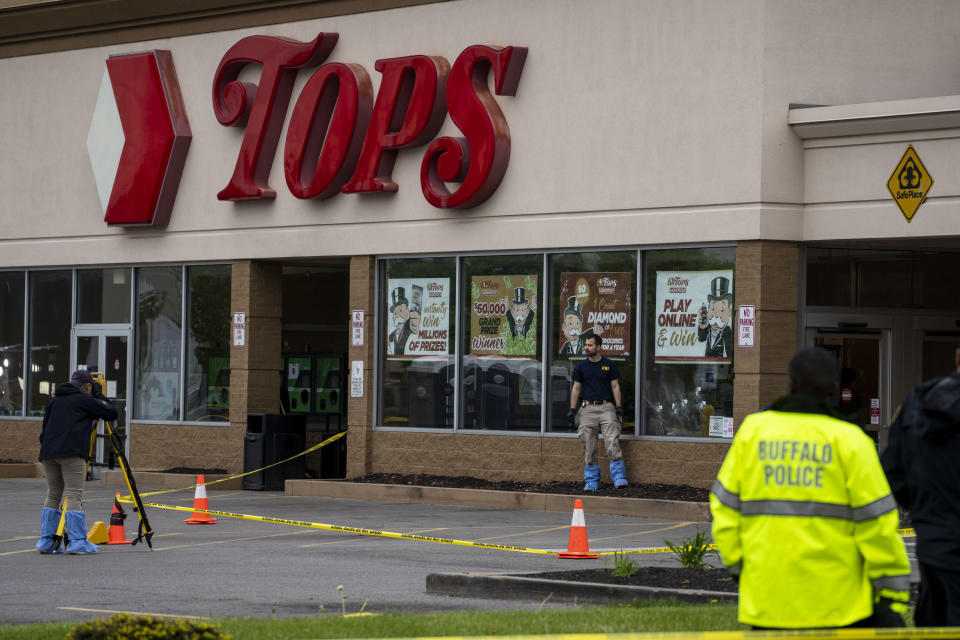 Bullet holes are seen in the window of Tops Friendly Market at Jefferson Avenue and Riley Street, as federal investigators work the scene of a mass shooting on May 16, 2022, in Buffalo, New York. 