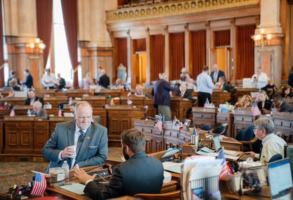 State Rep. Brad Sherman, R-Williamsburg, speaks with state Rep. Bobby Kaufmann, R-Wilton, on the House floor at the Iowa Capitol.