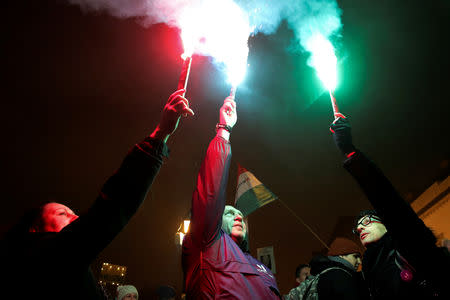 Demonstrators hold flares during a protest against a proposed new labor law, billed as the "slave law", at the Presidential Palace in Budapest, Hungary December 21, 2018. REUTERS/Marko Djurica