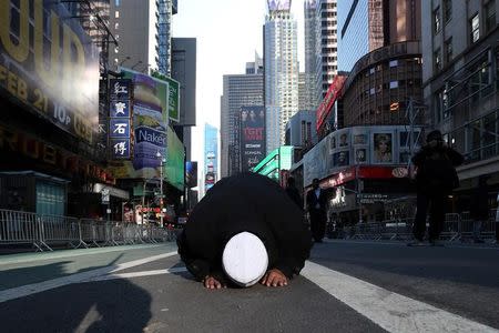 A Muslim man kneels on Broadway Ave. as he takes part in afternoon prayers during an "I am Muslim Too" rally in Times Square, Manhattan, New York, U.S. February 19, 2017. REUTERS/Carlo Allegri