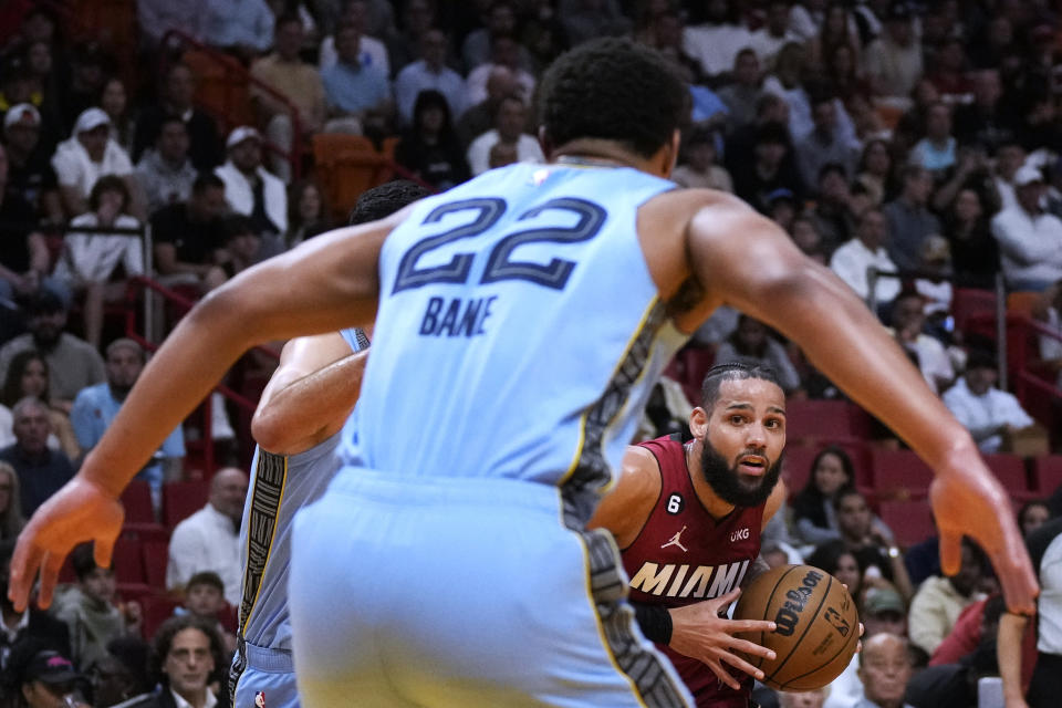 Miami Heat forward Caleb Martin (16) looks for an opening to pass as Memphis Grizzlies guard Desmond Bane (22) defends during the first half of an NBA basketball game Wednesday, March 15, 2023, in Miami. (AP Photo/Rebecca Blackwell)