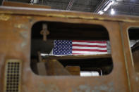 An American flag is visible through the rusted window of a destroyed Fire Engine inside Hangar 17 at New York's John F. Kennedy International Airport June 16, 2011. A program operated by the Port Authority of New York and New Jersey, The World Trade Center steel program, is selecting portions of the steel recovered from the Center and donating it to cities, towns, firehouses and museums around the U.S. and the world who request it for use in 911 memorial sites in time for the 10 year anniversary of the 2001 attacks. Picture taken June 16, 2011. (REUTERS/Mike Segar)