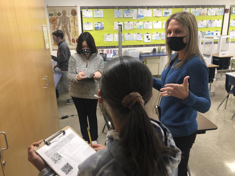 Jennifer Becker, right, Science Teacher at the Sinaloa Middle School, talks to one of her students in Novato, Calif. on Tuesday, March 2, 2021. The school just reopened Monday, Feb. 22, 2021 for in-person learning. (AP Photo/Haven Daily)