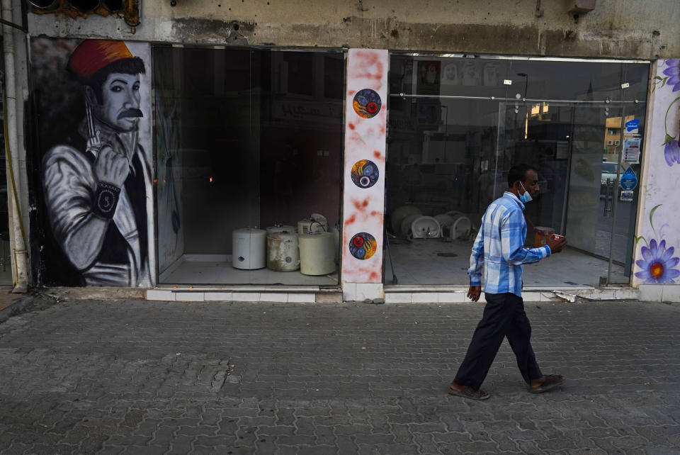 A man walks down the street holding a cup of karak in Dubai, United Arab Emirates, Wednesday, Aug. 24, 2022. Karak is the informal national drink of the United Arab Emirates, long priced at just 1 dirham, a bit less than 30 U.S. cents. But now, as supply chain shortages and Russia's war on Ukraine lead to price spikes across the world, Dubai's tea sellers are bumping up prices to 1.50 dirhams, or just over 40 cents. That's a blow to migrant workers who depend on the drink as a daily ritual offering respite and fuel. (AP Photo/Jon Gambrell)