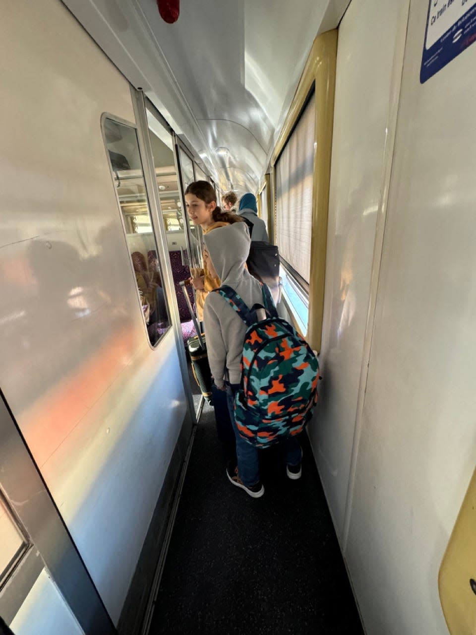 Kids walking down train hallway 