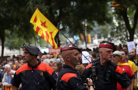 Catalan regional police officers stand in front of protesters who gathered in support of Catalan officials arrested in raids on government offices, outside a courthouse in Barcelona, Spain September 22, 2017. REUTERS/Susana Vera