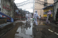 Health workers leave after screening people for COVID-19 symptoms at a residential building in Dharavi, one of Asia's biggest slums, in Mumbai, India, Friday, Aug. 7, 2020. As India hit another grim milestone in the coronavirus pandemic on Friday, crossing 2 million cases and more than 41,000 deaths, community health volunteers went on strike complaining they were ill-equipped to respond to the wave of infection in rural areas. (AP Photo/Rafiq Maqbool)