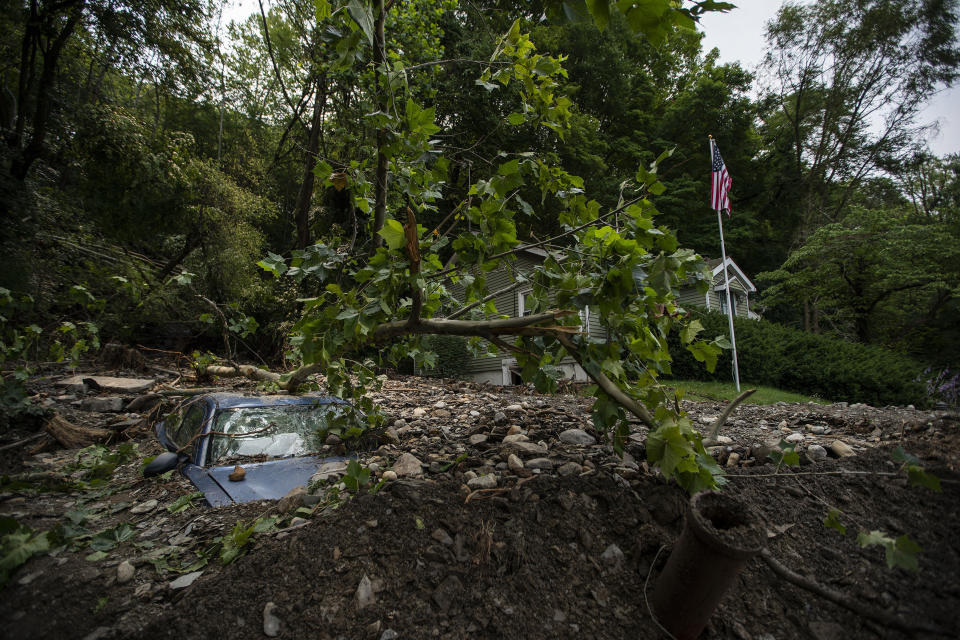 A car is buried in mud and rocks from recent flooding, Monday, July 17, 2023, in Belvidere, New Jersey. (AP Photo/Eduardo Munoz Alvarez)